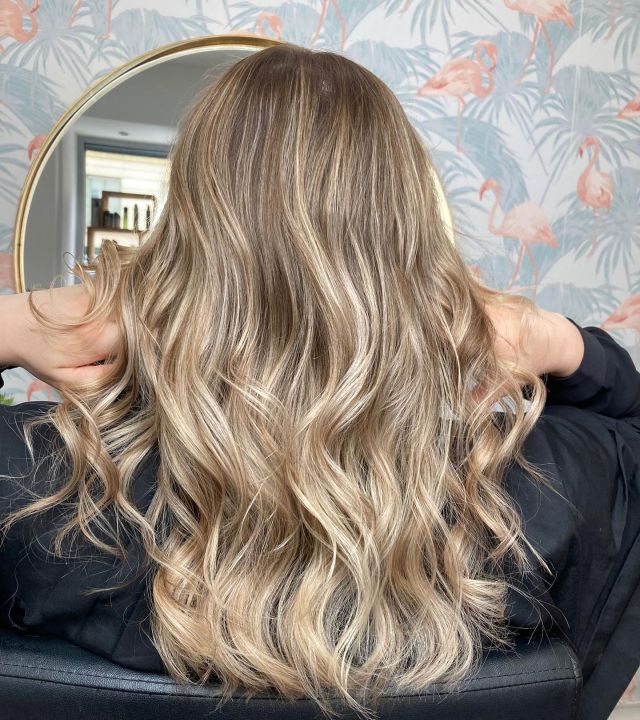 Goldblondes Balayage mit dunklerem Ansatz, im ARBUTI Salon fotografiert