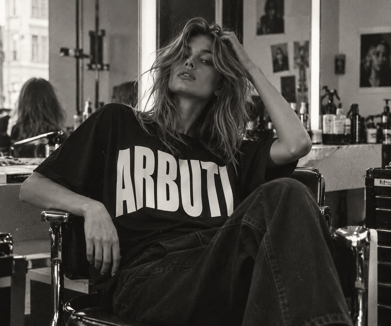 Mujer con camiseta de ARBUTI recostada en un sillón de peluquería, foto en blanco y negro